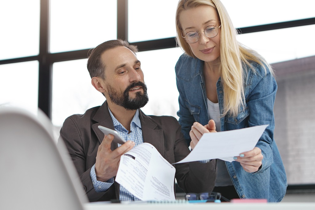 Customer and account manager in discussion, looking at papers