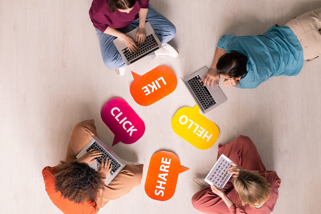 View from above showing 4 people on their devices engaged in social media activities